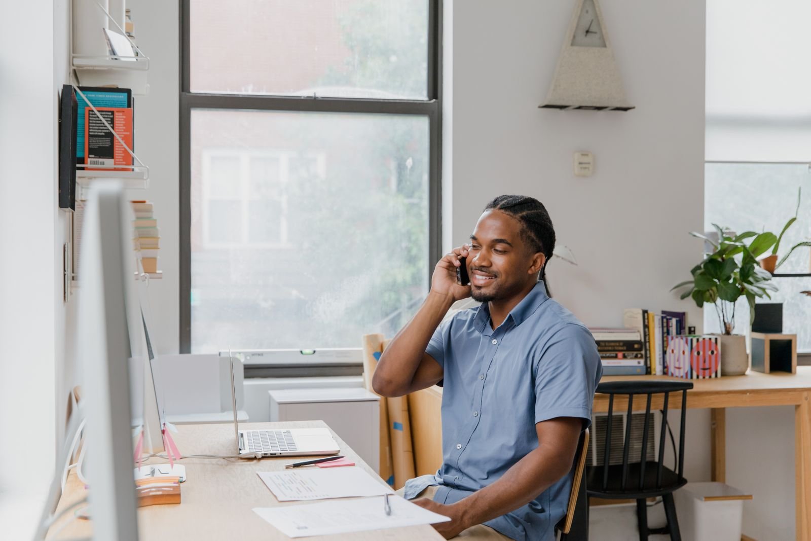 A host at a desk checking bookings on their phone.