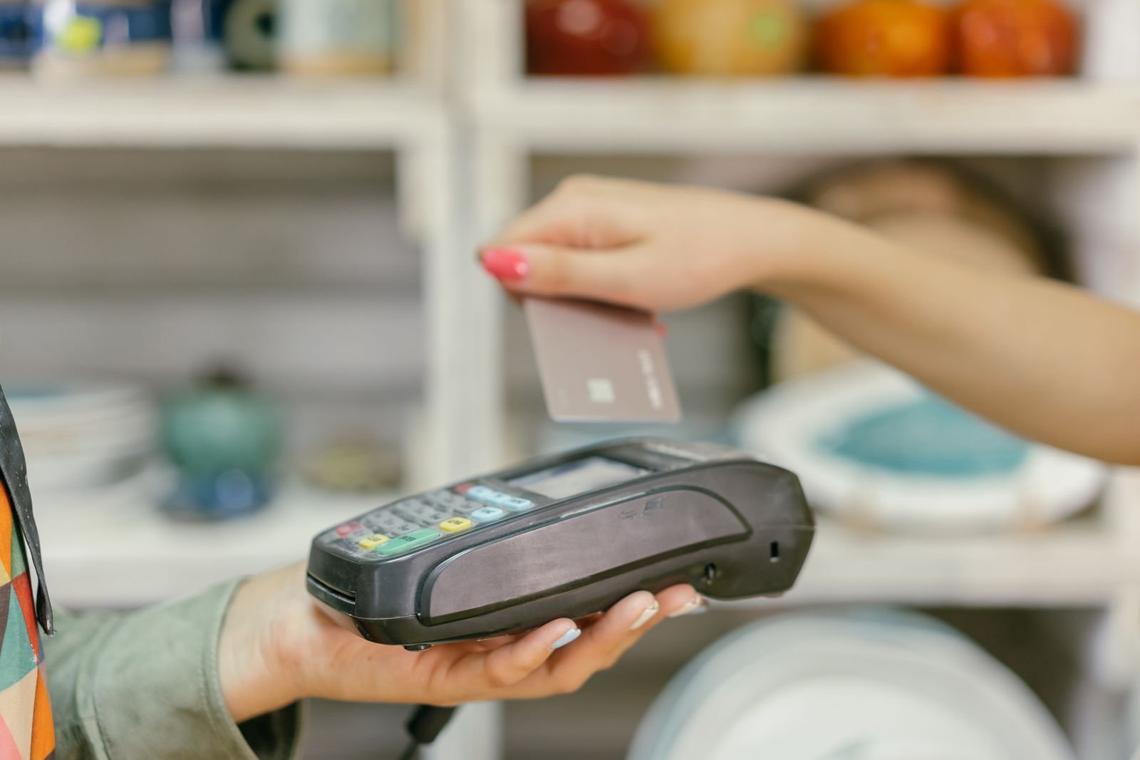 Customer tapping a card to pay at a point-of-sale terminal.